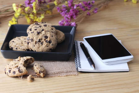 notebook on desk with coffee biscuit and pen, home office conceptの写真素材