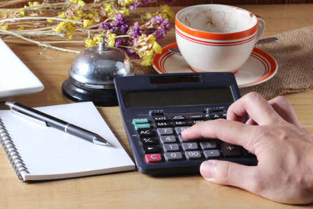 Hand with Office book, pen and a calculatorの写真素材