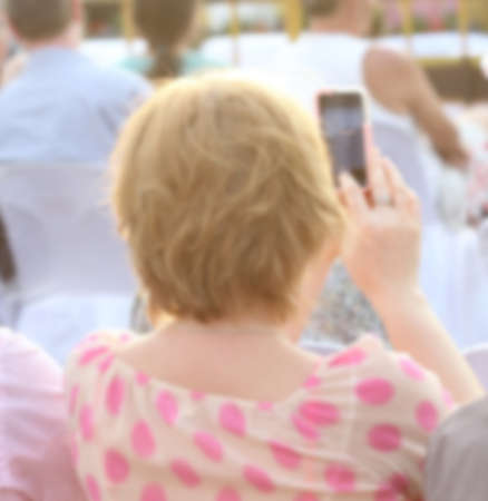 blurred people use smartphone, outdoor parkの写真素材