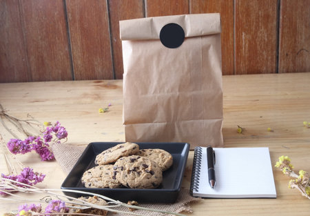 chocolate chip cookie with pen and notebook