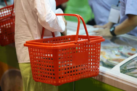woman holding shopping basket in supermarket, Thailandの写真素材