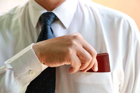 businessman hand pick up wallet from shirt pocketの写真素材