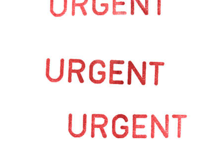 urgent rubber stamp on paper backgroundの写真素材