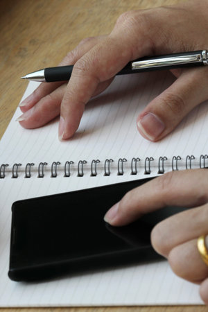 hand use smart phone and notebook