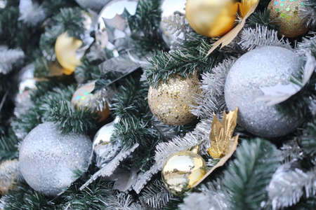 gold color Christmas ball hang on green pine tree with blurred night light new year party background.の写真素材