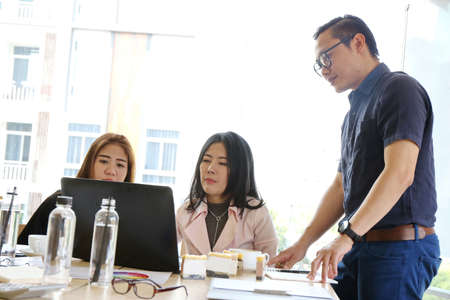 Happiness graceful businessman and smart woman people group present explaining colleagues latest profit financial data standing with dignified manner in office, Teamwork glad success job.の写真素材