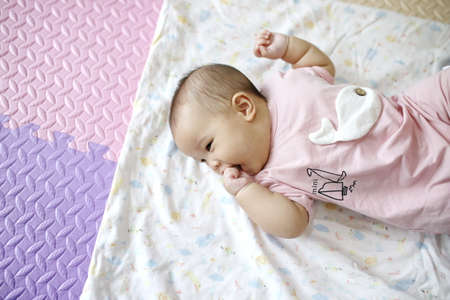 mother reach hand lift up play and show throws cute happy baby on sky in house living room at morning time after awake concept. enjoy parenting emotion and good feeling family. smart generationの写真素材