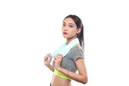 Charming tan skin Asian woman with exercise suit hand hold pure water bottle isolated on white background, Presenting fitness and good healthyの写真素材