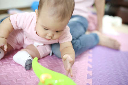 mother reach hand lift up play and show throws cute happy baby on sky in house living room at morning time after awake concept. enjoy parenting emotion and good feeling family. smart generationの写真素材