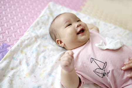 mother reach hand lift up play and show throws cute happy baby on sky in house living room at morning time after awake concept. enjoy parenting emotion and good feeling family. smart generationの写真素材