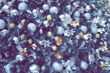 gold color Christmas ball hang on green pine tree with blurred night light new year party background.の写真素材