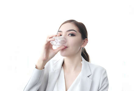 Young pretty woman sitting at opened window looking outside enjoys of rest. charming businesswoman with suit hand hold hot coffee cup drink in morning. Good life feeling roasted bean aromaの写真素材