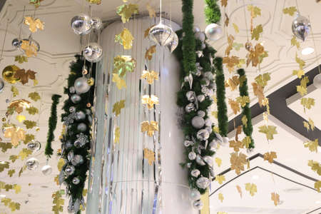 gold color Christmas ball hang on green pine tree with blurred night light new year party background.の写真素材
