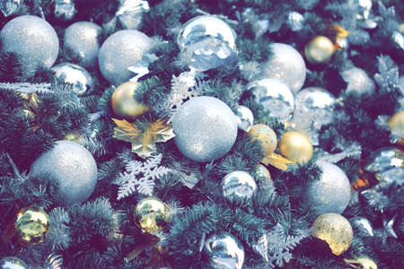 gold color Christmas ball hang on green pine tree with blurred night light new year party background.の写真素材