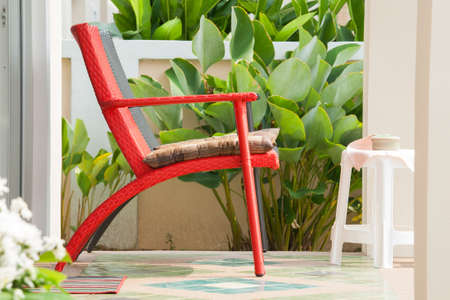 Relax by sit on the red chair in front of you home の写真素材