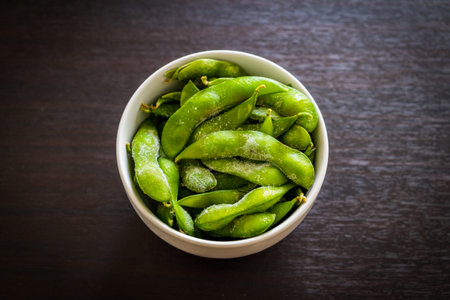 Green Japanese Soybean in white bowl on table wood.
