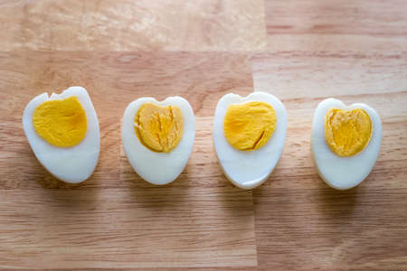 Heart shaped boiled eggs on wood tableの写真素材