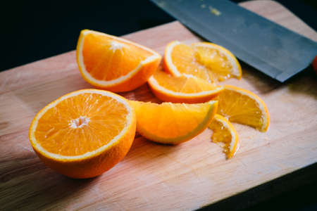 Sliced orange fruit and knife on Cutting boardの写真素材