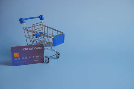 Cradit card in shopping cart on the blue background.の写真素材