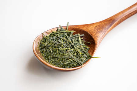 Tea leaves on a wooden spoonの写真素材