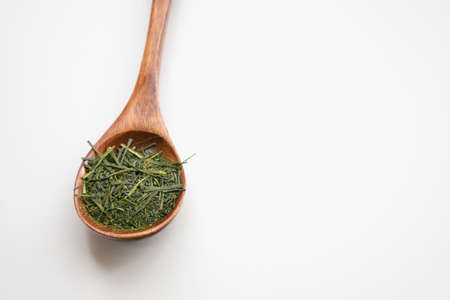 Tea leaves on a wooden spoonの写真素材