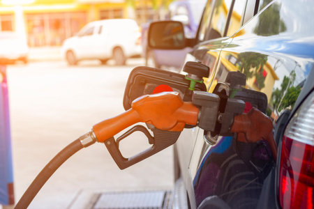 fuel nozzle. Filling gasoline to black car at gas station
