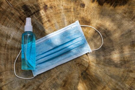 Top view alcohols gel and Medical mask on real wood table with copy space for text or design.の写真素材