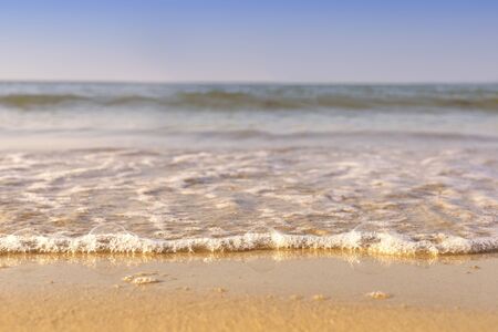 Soft wave from sea come to wet sand beach with blur clear sky background. With copy space for text or designの写真素材