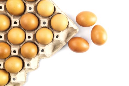 Top view chicken fresh eggs in cardboard egg box holder and 3 fresh eggs outside isolated on white background.の写真素材