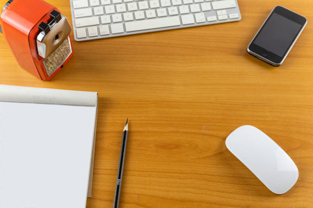 Top view office desk with mouse, laptop, Mobile phone, keyboard, bill book and pencil on wood table...