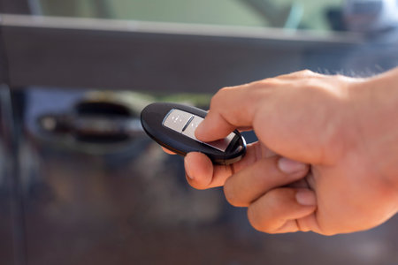 Hand man hode car remote for open the car. Soft focus and focus selective remote.