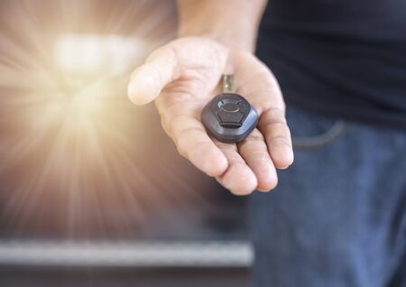 Car key remote on hand. Hand man giving a car key. の写真素材