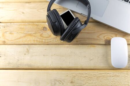 Top view headphone, laptop, Mouse and music player portable on wood table. With copy space for text or design.の写真素材