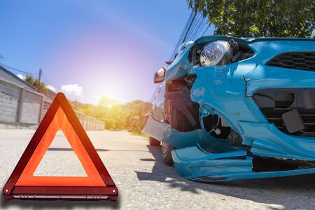 Front of blue color car big damaged and broken by accident on city street parking can not drive any more on road have triangle. With copy space for text or designの写真素材