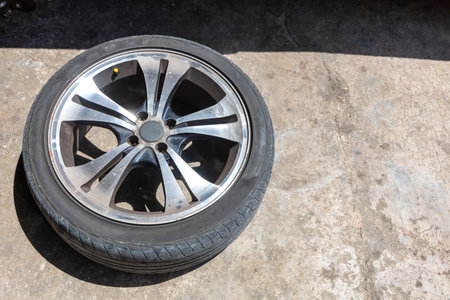 One car wheel with tyre on ground. With copy space for text or design.