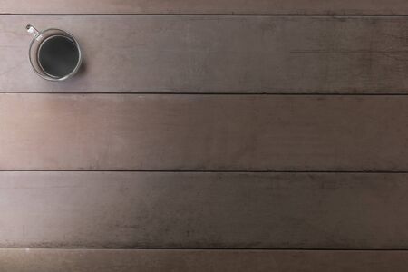 Top view black coffee cup on old wood table. coffee in handle cup with copy space. Hot black coffee with smoke.の写真素材