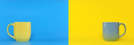 Blue cup on yellow background and yellow cup on blue background with copy space. Blue cup with handle and yellow with handle.の写真素材
