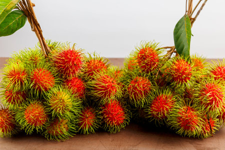 Bunch of fresh ripe rambutan fruits on Wooden Tableの写真素材