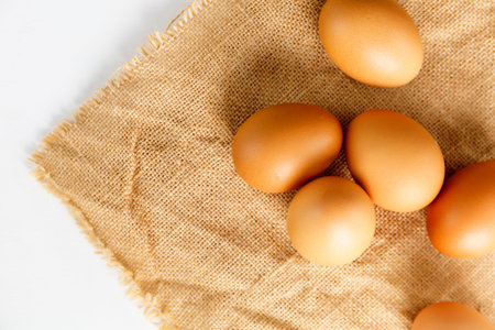 Close up Top view fresh chicken eggs on linen tablecloth with copy space. 