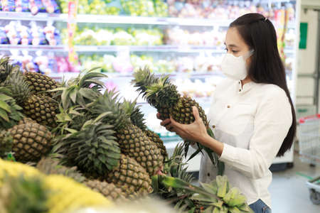 Asian woman long hair wearing protective face mask  in supermarket department store.の写真素材