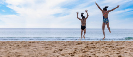 Motion movement happy two children wear swimwear running and jumping from beach to the sea. Happy...