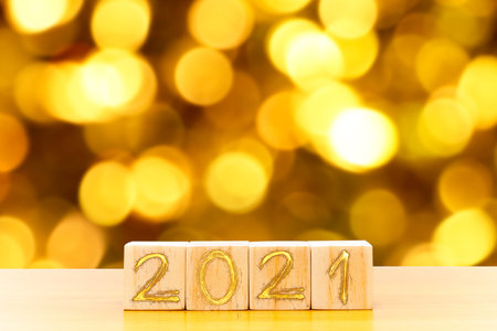 Wooden cubes with 2021 and happy new year with blur bokeh background, banner with copy space. New...