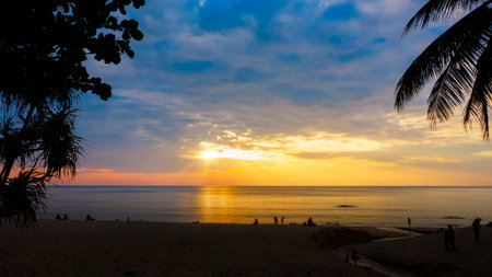 Silhouettes of group of people during the sunset in Seaside beach. Beautiful sunset over the sea with silhouettes happy group of people relax. Holiday and summer conceptの写真素材