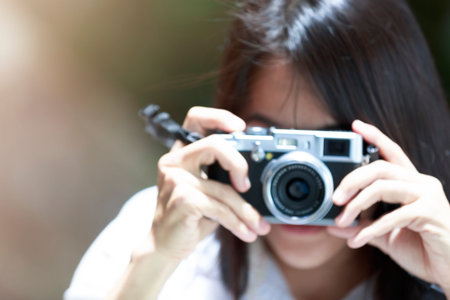 Blur focus of trvel women long hair use camera shot of something. Blur Asian women use small camera...