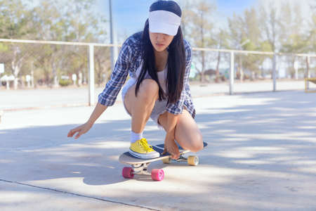 Young asian women play surf skate board at park skate ramp outdoors on morning. Happy women play surfskate board at park . Sport activity lifestyle conceptの写真素材