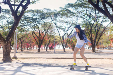 Young asian women play surf skate board at park skate ramp outdoors on morning. Happy women play surfskate board at park . Sport activity lifestyle conceptの写真素材