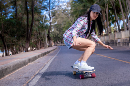 Young asian women play surf skate board at beach road outdoors on morning. Happy women play surfskate board on beach road . Sport activity lifestyle conceptの写真素材