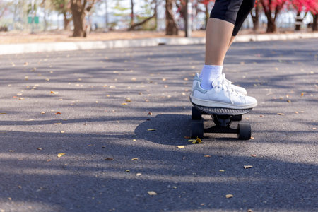 Close-up and motion movement Asian women surf skate or skateboard outdoors on beautiful morning....