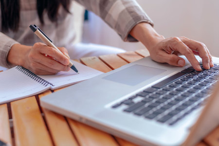 Close up young business woman hands with pen writing notes on paper. female executive sitting at...