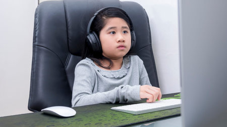 Asian girls study online with laptops. Kid wear headset typing keyboard notebook learning using...